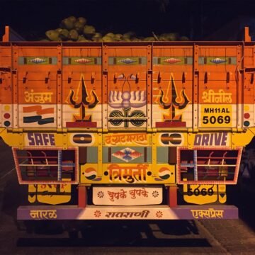 Coconut delivery truck being unloaded at night.